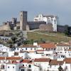 Town of Arraiolos, Portugal. The castle walls are at the top of the hill, with the town down below. The contrast between the whitewashed houses at the base of the hill and the dark castle walls is most effective. [Photo by courtesy of João Correia]