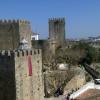 Castle of Bragança on the left, with crenelated toweres surrounded by walls. Access to the castle can be seen on the right. [By courtesy of Luisa Cabrita]